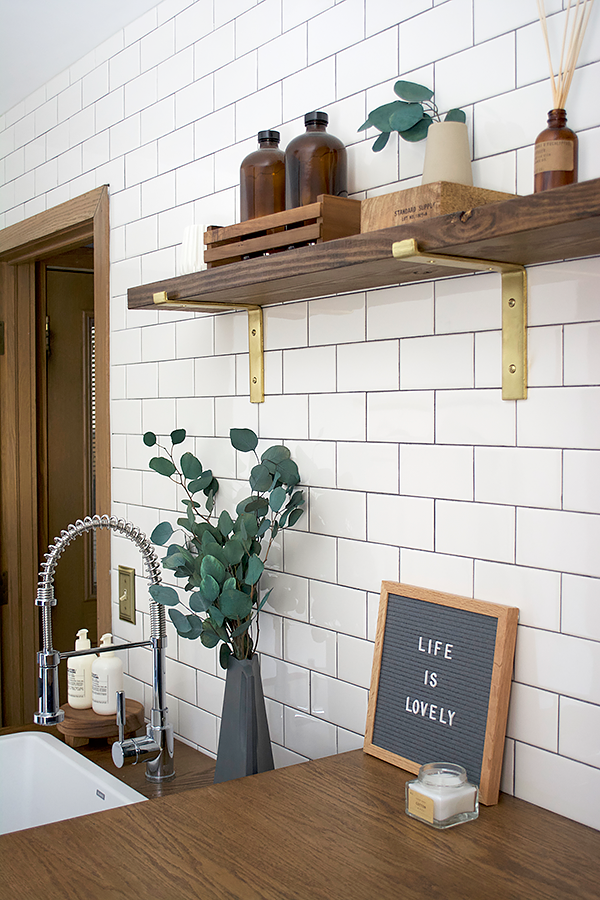 white subway tile and open shelving in a laundry room